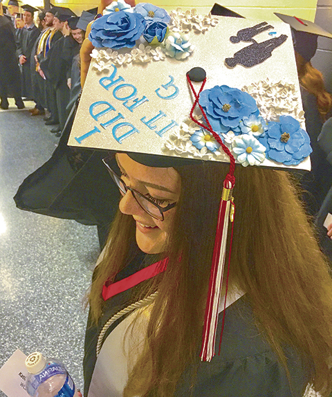 Correspondent photo / Sean Barron Katie Marino of Niles displays her cap with a capital “G,” the first letter of her son’s name, whom she credits for providing the inspiration for her to graduate from Youngstown State University. Marino was among the more than 400 undergraduates who took home degrees during Sunday’s first fall commencement at Beeghly Center.